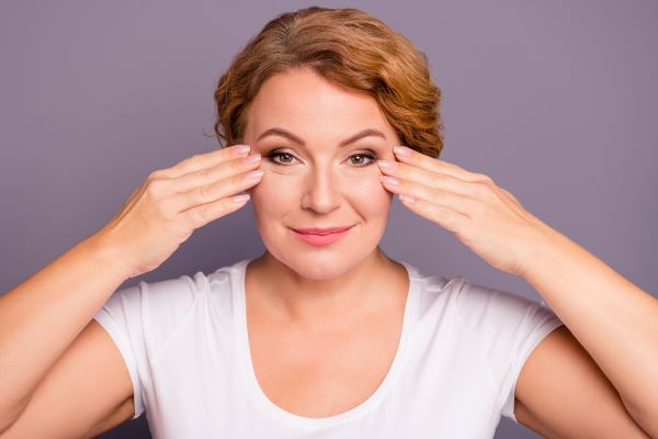 Rejuvenescer o olhar: mulher madura mostrando resultados do tratamento para a área dos olhos.