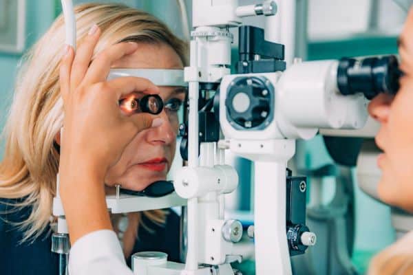 Oftalmologista realizando exame ocular em paciente para detectar condições raras oculares.
