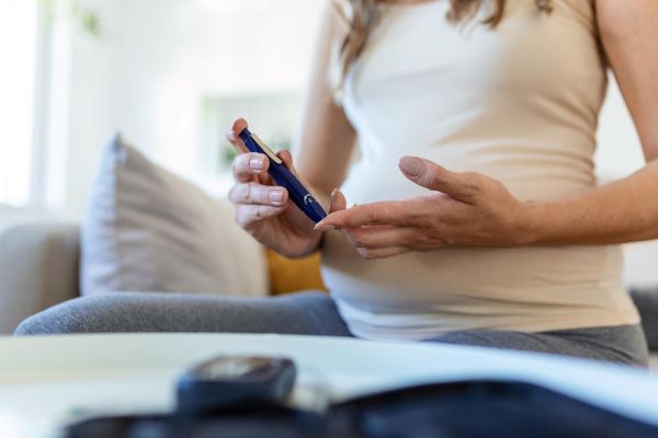 Mulher grávida medindo a taxa de glicose no sangue - A diabetes é uma das causas de alterações visuais na gestação. 