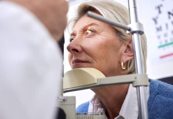 Mulher madura realizando exames oftalmológicos para posterior realização de procedimentos estéticos nos olhos.