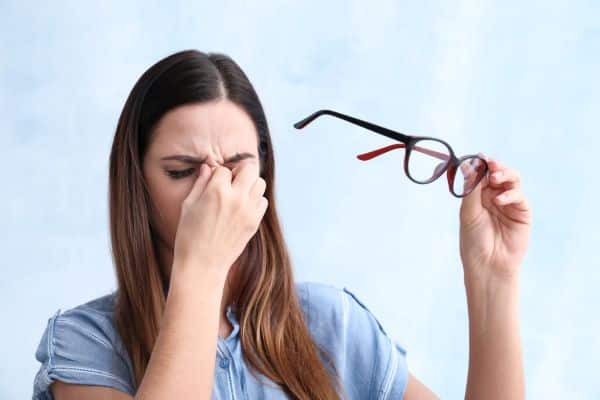 Mulher coçando os olhos por conta de alergia ocular sazonal
