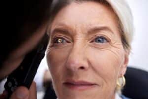 Linda mulher idosa sendo examinada por médico oftalmologista para identificação de catarata.
