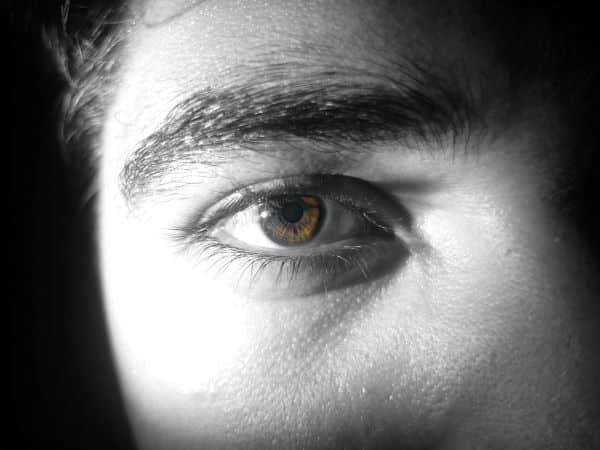 Close up de um olho castanho de um jovem.