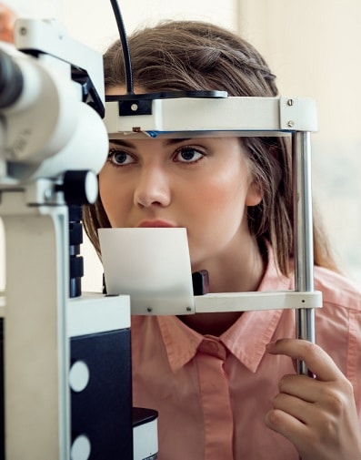 Jovem com cabelos longos castanho-claros e olhos escuros, faz exames oculares regulares para controle do glaucoma.