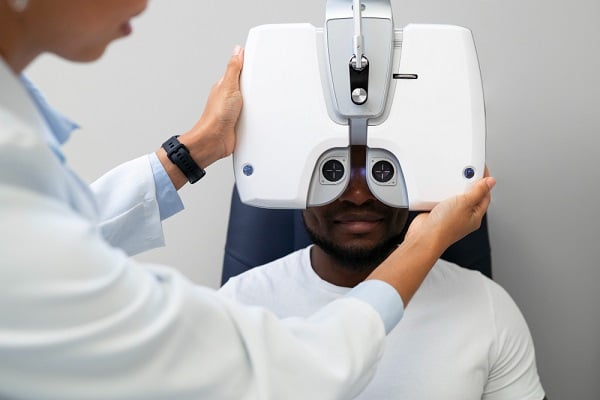 Jovem negro realizando consulta oftalmológica para prevenir problemas oculares como a síndrome da visão do computador.