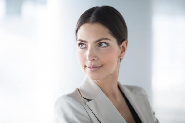 Mulher bonita , cabelos e olhos escuros, vestindo blazer claro.  